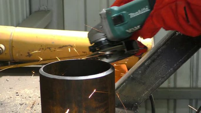 工人用研磨机切割金属的特写。