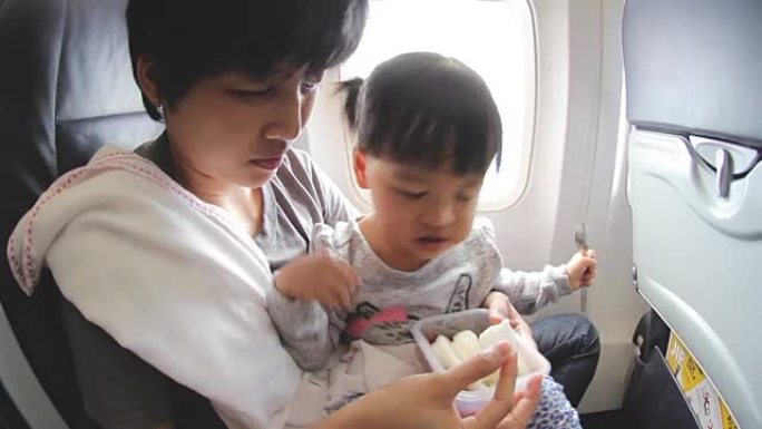 高清: 母亲在飞机上给女儿喂水果