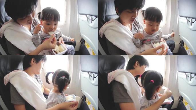 高清: 母亲在飞机上给女儿喂水果