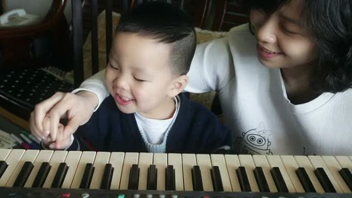 中国母亲和儿子玩有声音的键盘