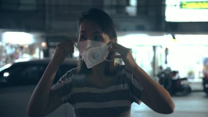 晚上有口罩保护的女人免受空气污染
