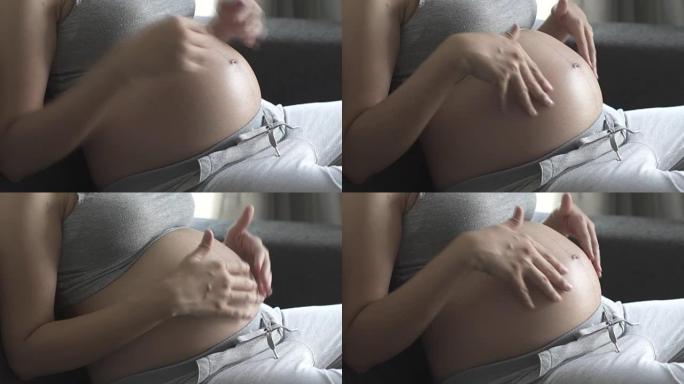 孕妇在沙发上抚摸腹部