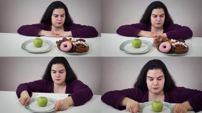 沮丧的胖白人妇女把盘子和甜点放在一边，吃健康的苹果。悲伤丰满的女孩节食。有超重问题的女人的肖像。