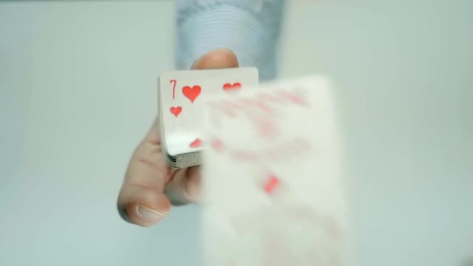 手挤压一副扑克牌，它们弯曲并向前飞