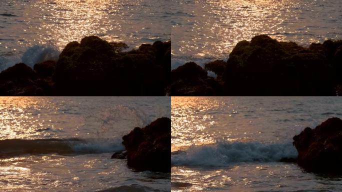 太阳从海洋表面反射，海浪在沿海岩石上破裂