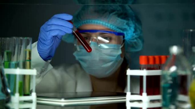 实验室技术员用血清分析试管并在片剂上进行分型结果