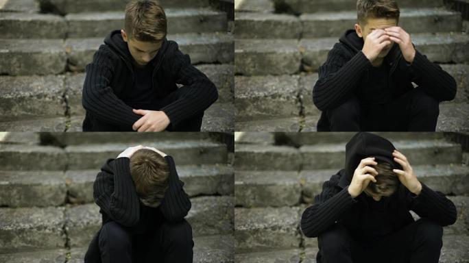受惊的孤独男孩坐在旧的破裂台阶上，战争的回声，生活中的悲伤