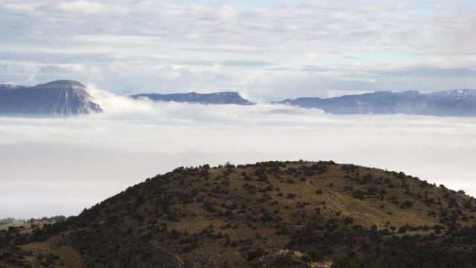 乌云/雾反转的时间间隔在科罗拉多州西部的大山谷上，背景是书本悬崖和加菲猫山