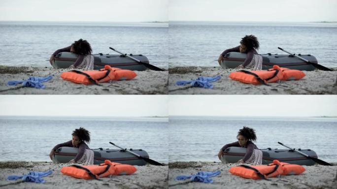 痛苦的女人躺在船上等待帮助，在暴风雨，自然灾害中幸存下来