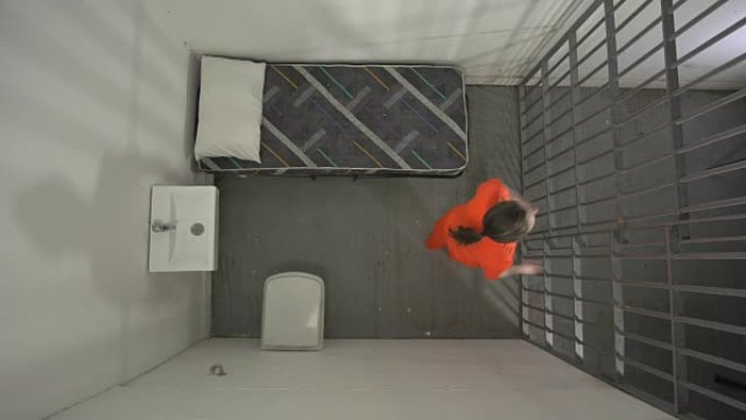 从上方4k: 监狱牢房中的女囚犯在地板上起搏