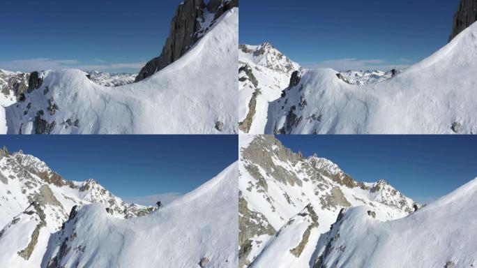 男性登山者登上陡峭的积雪覆盖的山脉的空中无人机视图