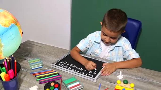 男孩在黑板上画粉笔。