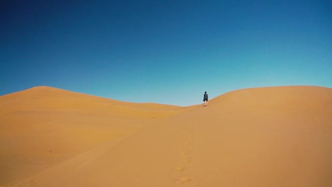 日落时在撒哈拉沙漠中行走的女人