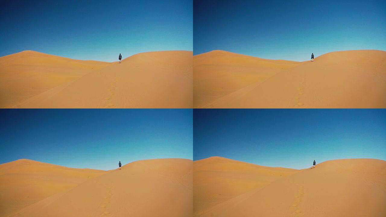 日落时在撒哈拉沙漠中行走的女人