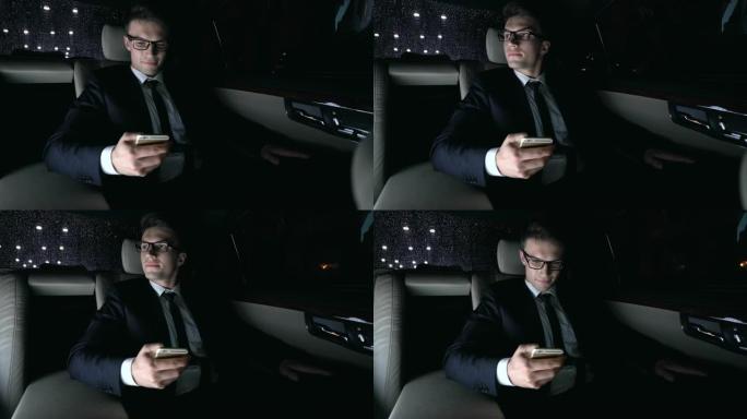 穿着西装的男性在开车回家时与女友在汽车后座上发短信，调情