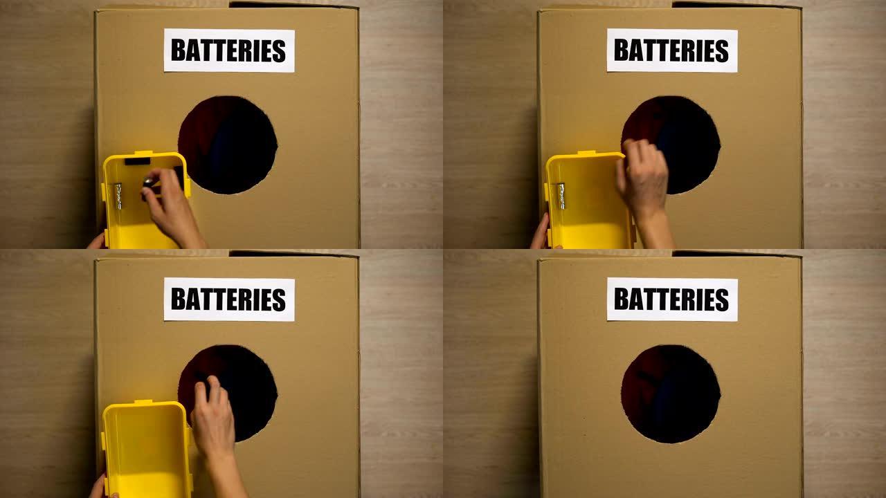 女性将废旧电池扔在盒子中用于回收，处理重金属