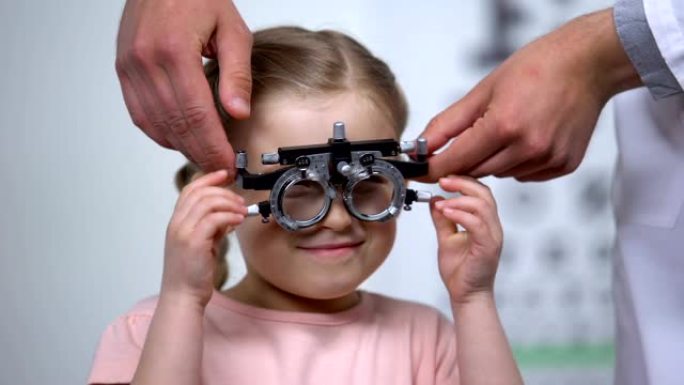 验光师给小女孩戴上特殊眼镜，诊断懒惰的眼病