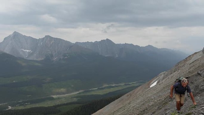 男性登山者穿越山谷上方的山面