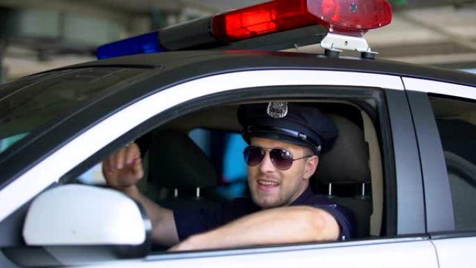 年轻的警察戴着太阳镜在车里，对着镜头微笑，重要的工作