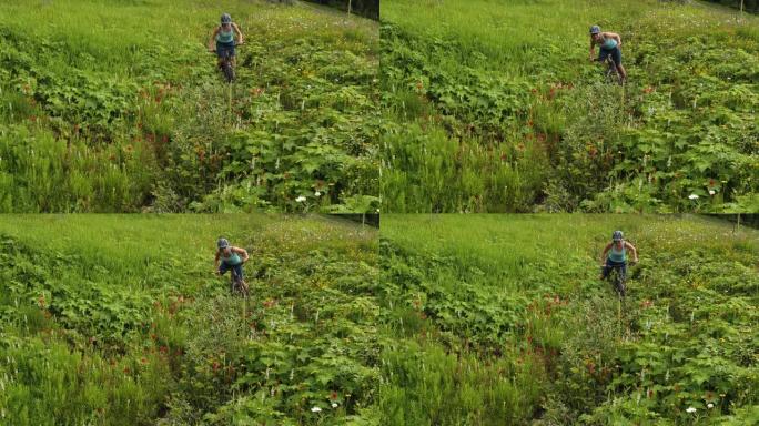 女山地自行车手在山上草地上踩踏