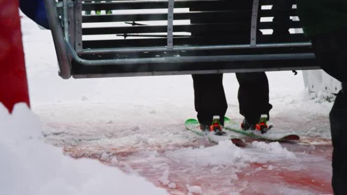冬季，滑雪缆车在滑雪胜地接一名滑雪者和几名滑雪者的慢动作镜头