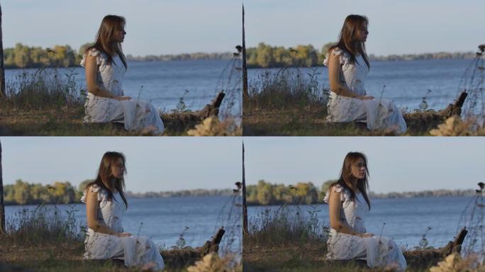 神秘的高加索女人坐在湖岸上环顾四周