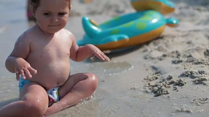 婴儿在沙滩上的海边玩耍