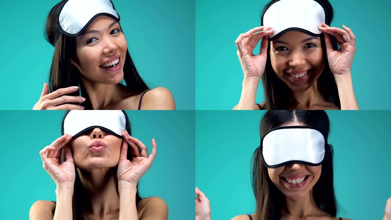 轻浮的亚洲女士戴着眼罩，将空气亲吻送入相机，心情愉快