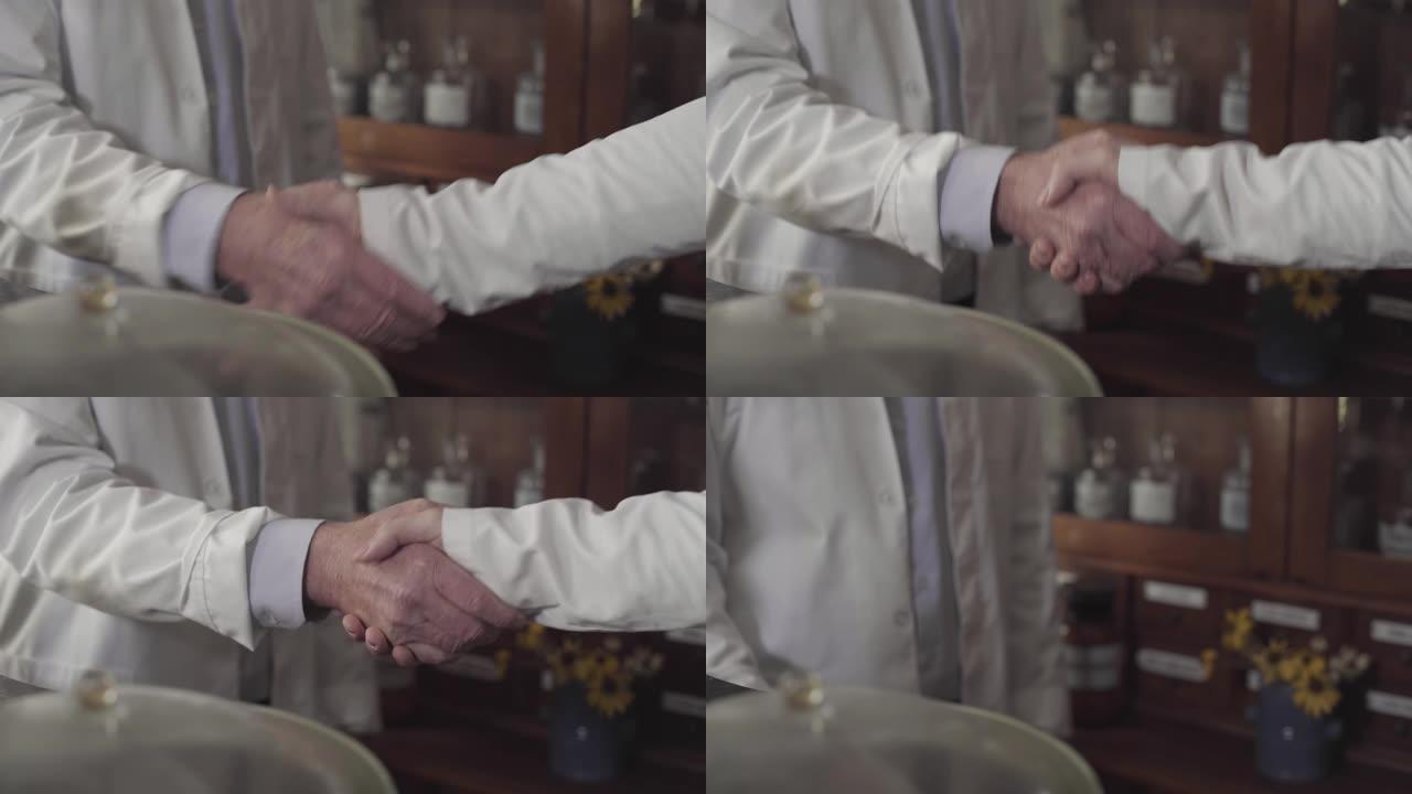 白袍高加索人握手的特写。医务工作者握手。医疗保健。医学。