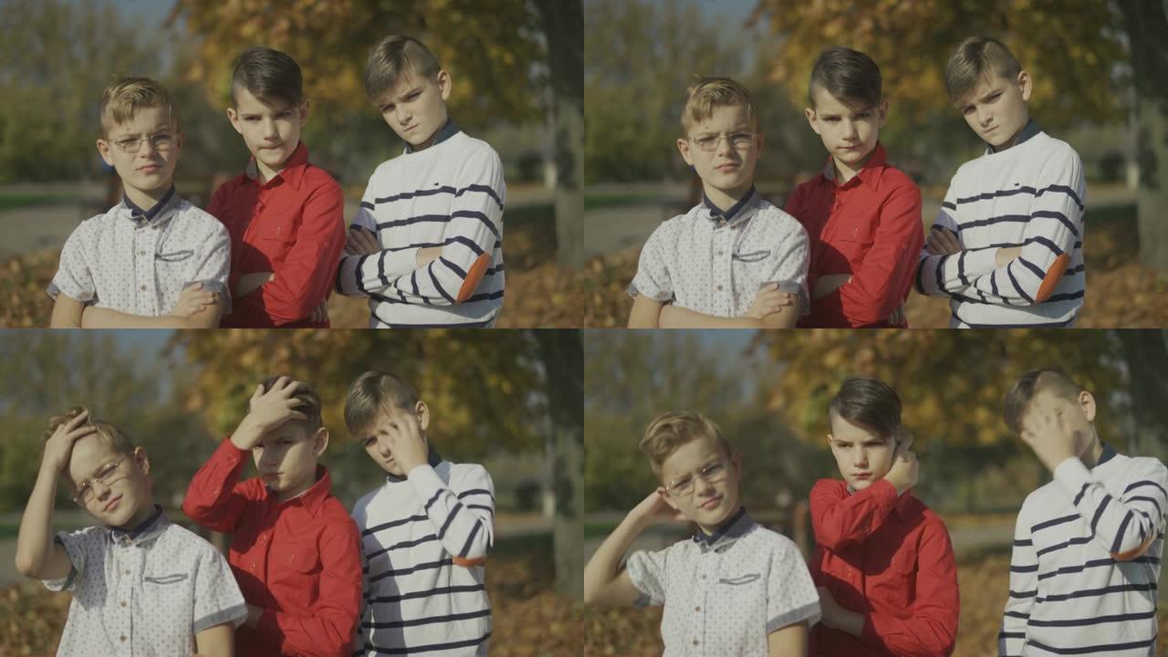 三个男孩在镜头前摆姿势，在户外直发。男孩们在一起。