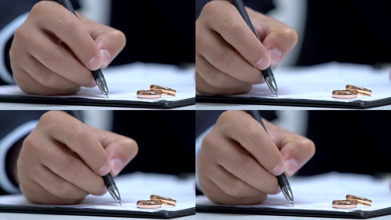 男律师在文件中填写数据，订婚戒指在桌子上，家庭法院