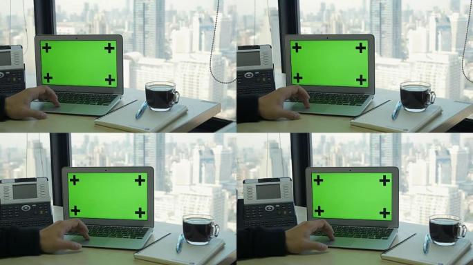 现代高层办公楼中带有隔离绿屏的笔记本电脑