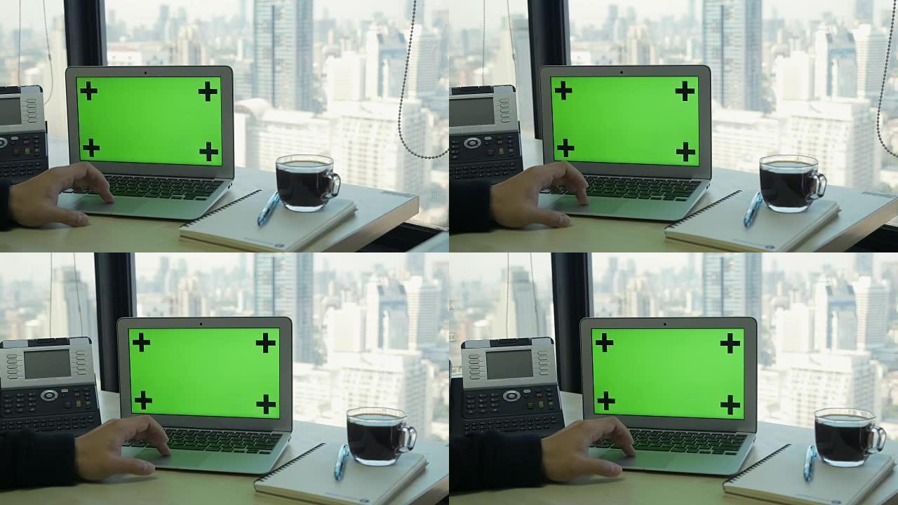 现代高层办公楼中带有隔离绿屏的笔记本电脑