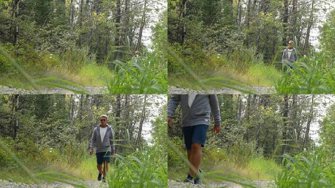 男性徒步旅行者穿过草丛森林