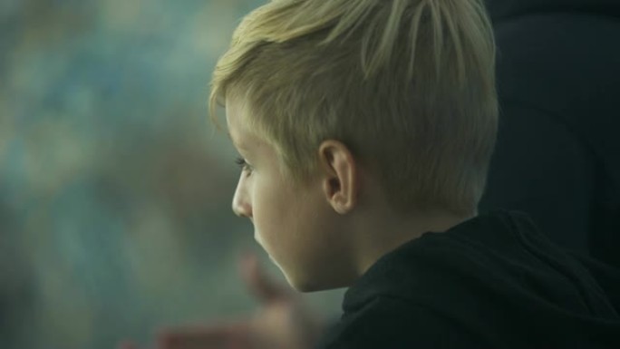 男孩在体育场情绪激动地观看体育比赛，大喊支持，特写镜头