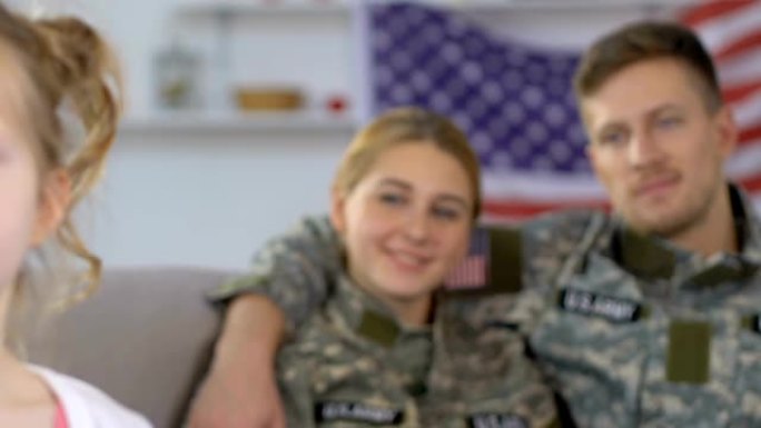 幸福的父母穿着军装看着女儿，美国民族的骄傲