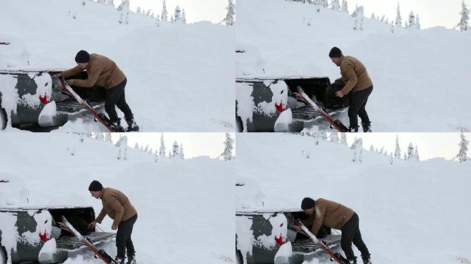 男子从皮卡车上拉滑雪板和行李，暴风雪
