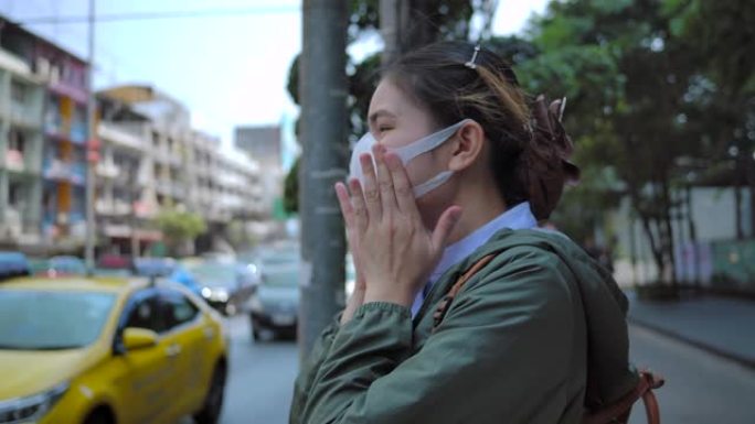 4k亚洲女性戴着鼻罩，防止空气中PM 2.5灰尘。