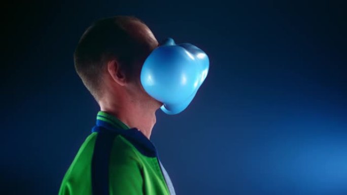 SLO MO LD蓝色充满水的气球击中了一个男人的脸而没有弹出