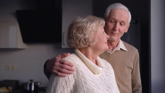 老年夫妇微笑着看着窗户，对未来乐观，保险