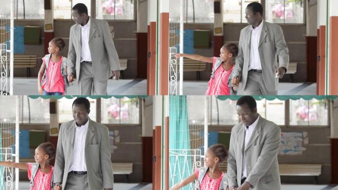 美丽的黑人小女孩与父亲一起走过学校走廊，同时指着谈话