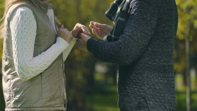 男子将订婚戒指戴在女性手指上，参加秋季公园的提议