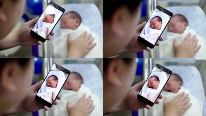 父亲用智能手机给男婴拍照