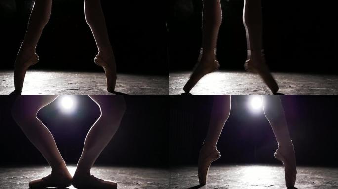 黑色背景上的足尖鞋美丽的腿。芭蕾舞练习。慢动作。
