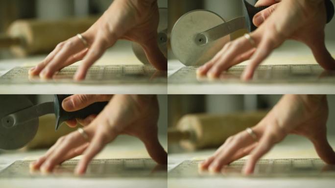 一名妇女的手在使用糕点轮 (披萨切割机) 切割糕点时握住一把清晰的尺子