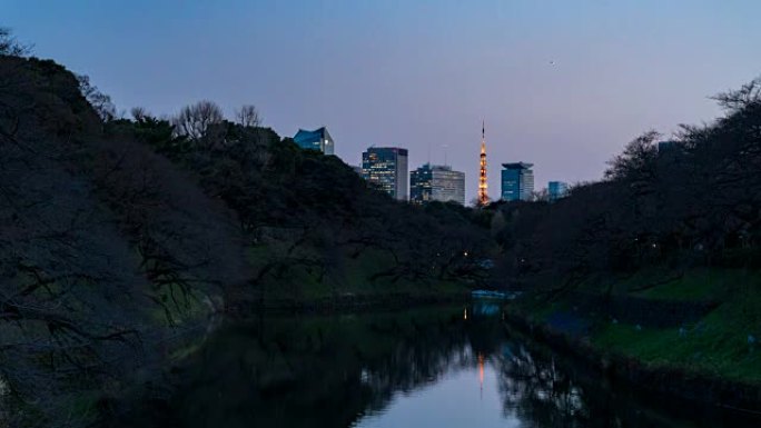 4k日夜延时: 位于皇宫千鸟口护城河后面的东京摩天大楼。摩天大楼中照亮了东京塔