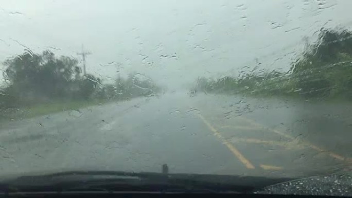 汽车雨刮器正在缓慢清除雨水并在道路上行驶