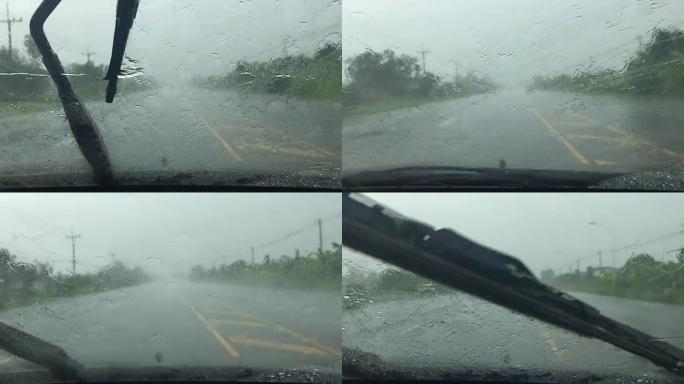 汽车雨刮器正在缓慢清除雨水并在道路上行驶