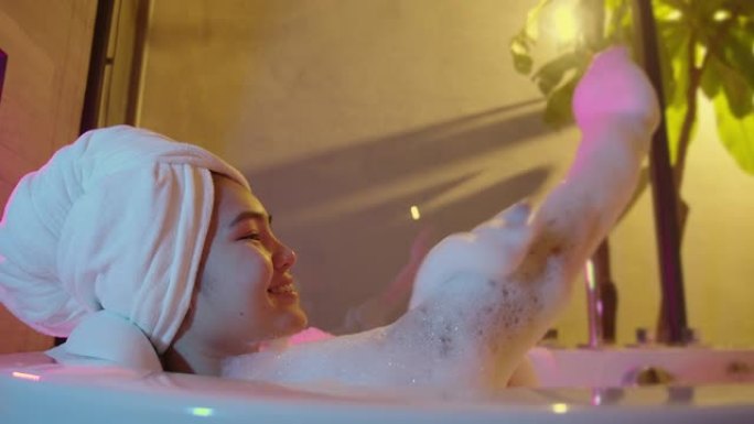 RGB轻女人她在热水浴缸里泡澡。