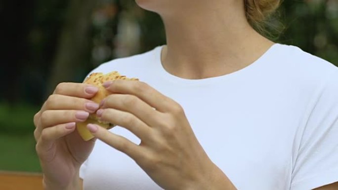 女人吃汉堡，感觉上腹部突然疼痛，胃炎，垃圾食品